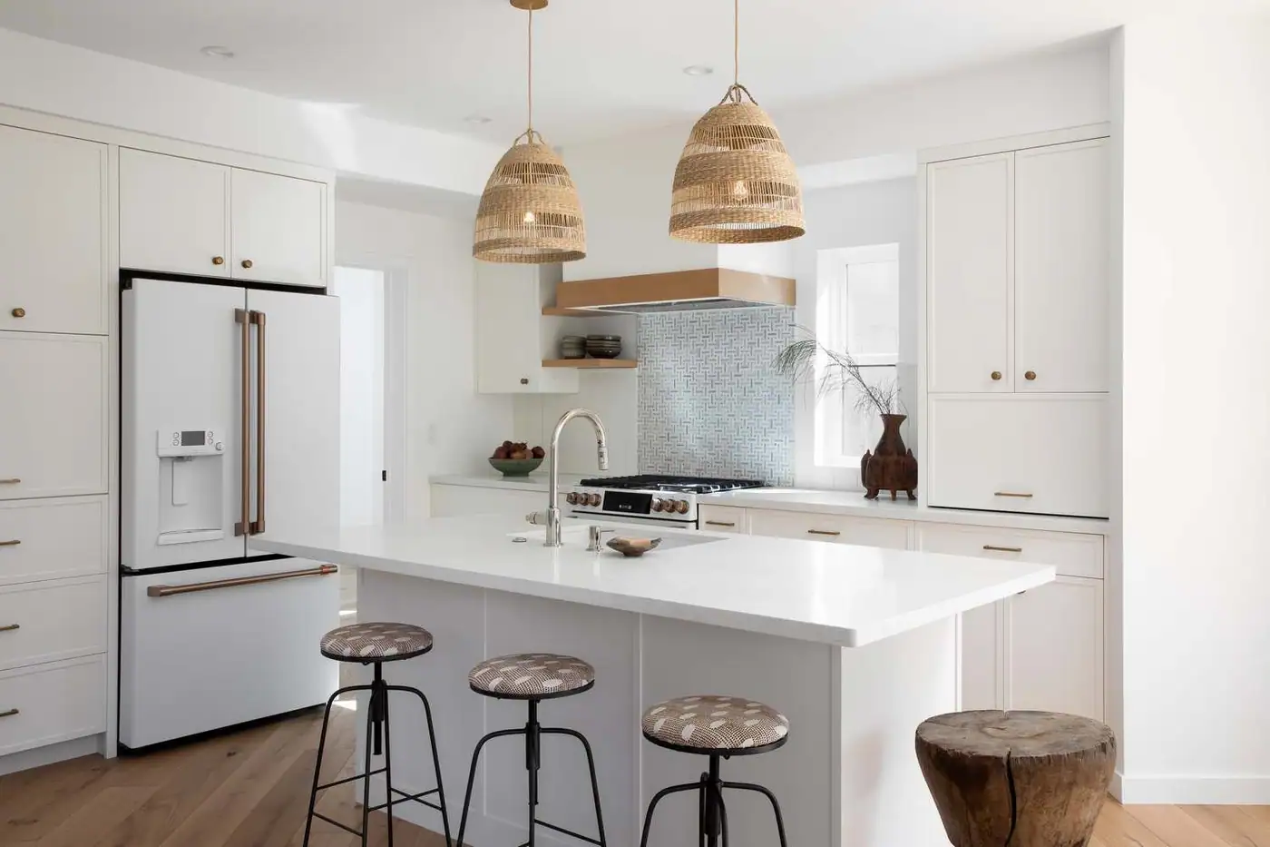 Remodeled white kitchen with an island and woven pendant lights, Riverview project
